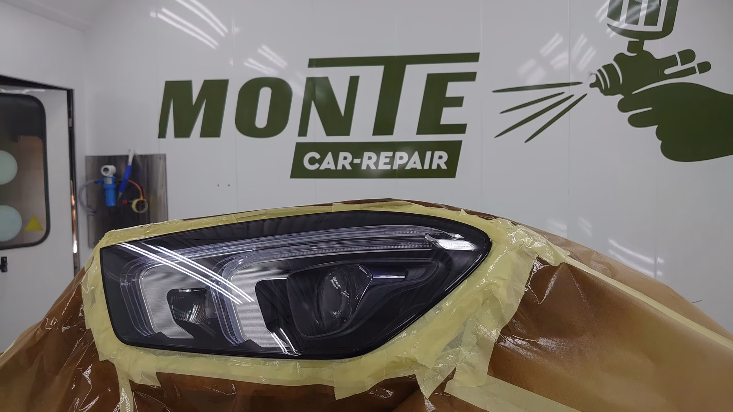 in spuitcabine auto ingepakt met logo Monte Car-Repair